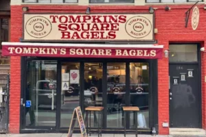 Tompkins Square Bagels East Village storefront with red brick exterior and outdoor seating.